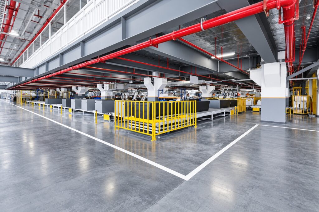 Organized manufacturing floor with production equipment and safety barriers